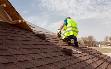 A TAG Roofing & Exteriors crew member installing shingles with a nail gun on a roof in Cedar Park, Texas