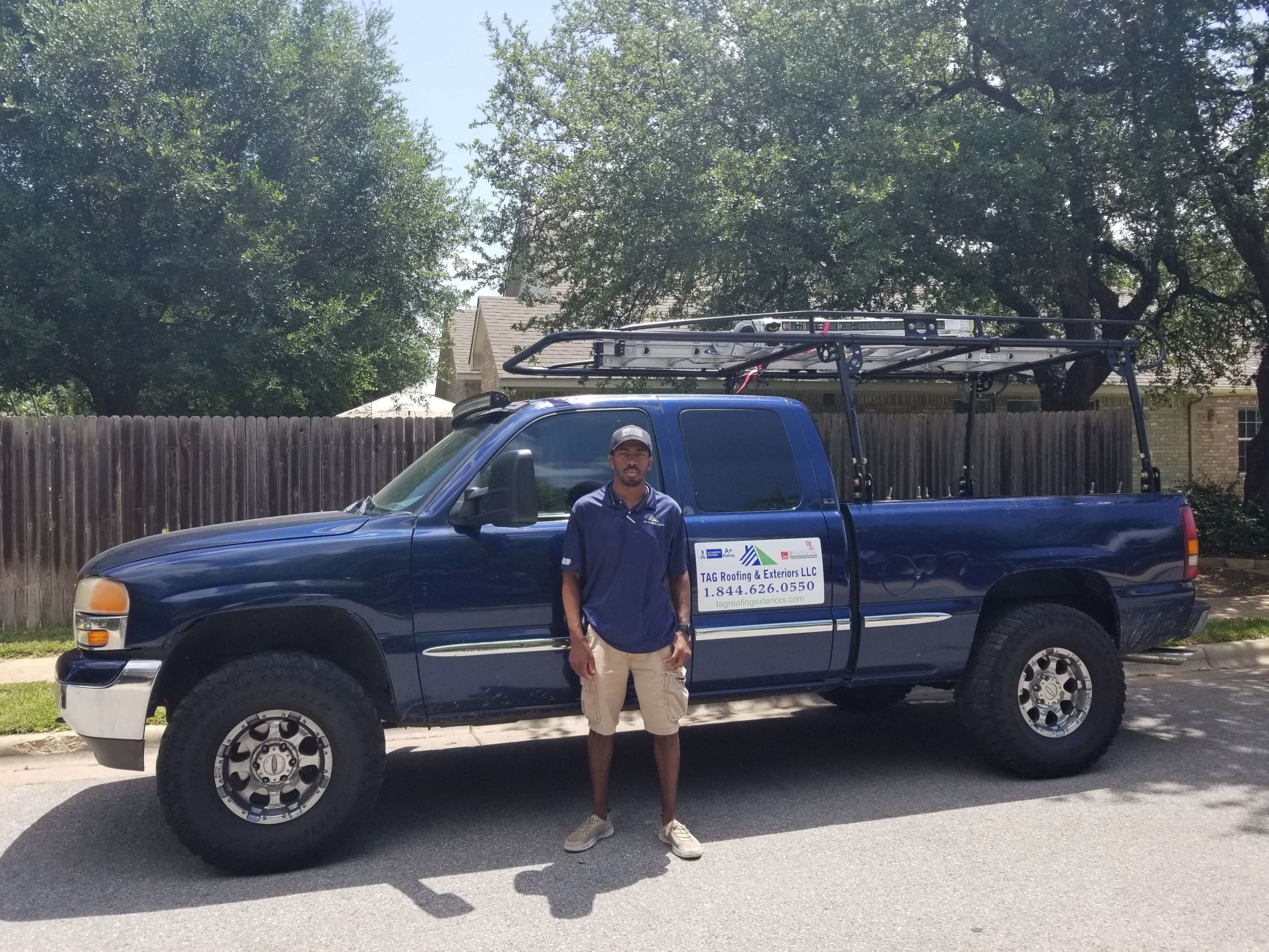 certified roofer standing next to a Tag Roofing truck.