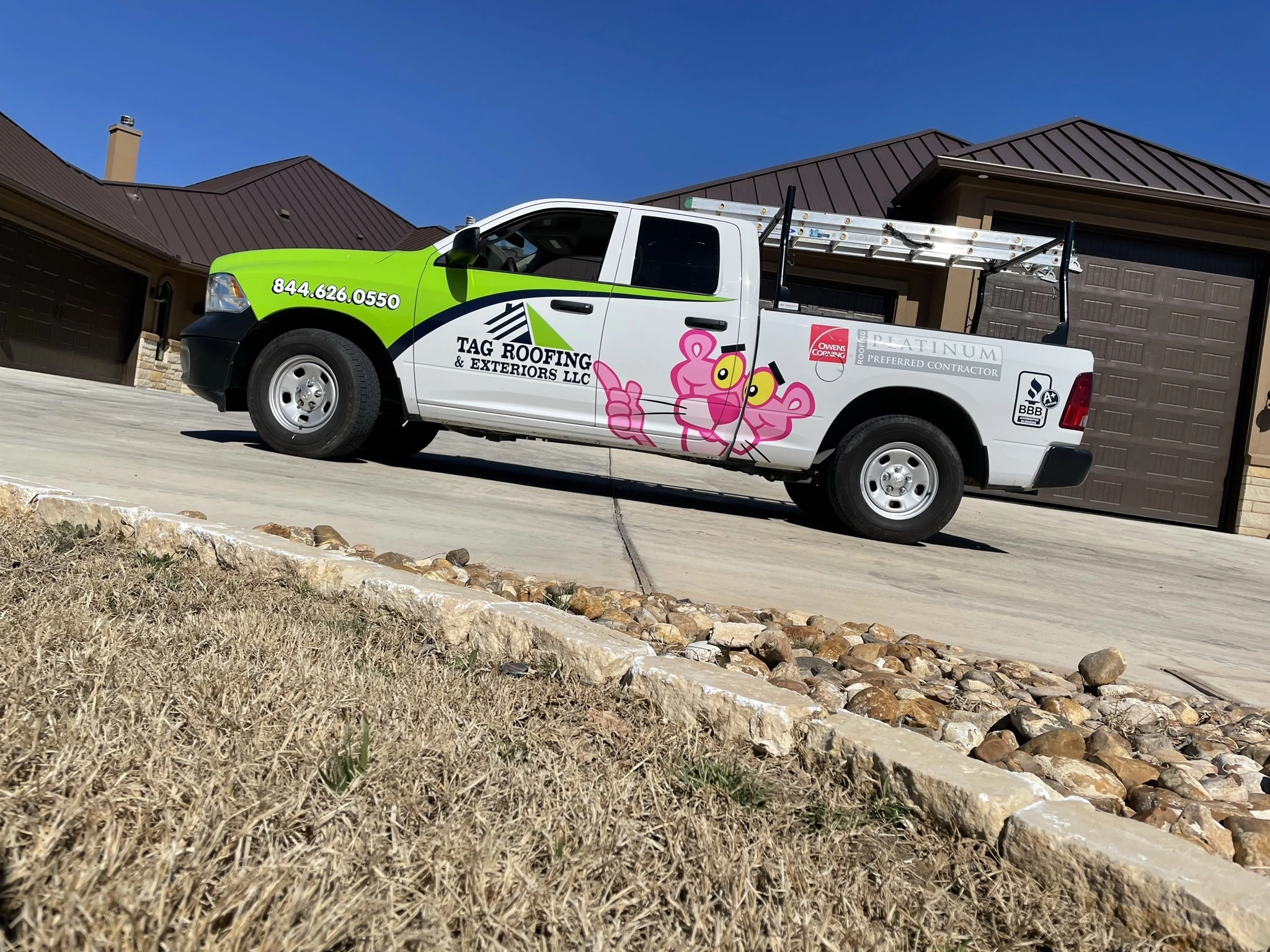 A TAG Roofing & Exteriors company vehicle in front of a home with a new roof.